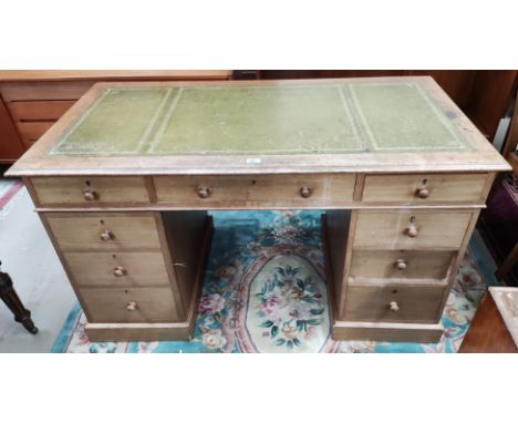 A Victorian kneehole desk with 8 pedestal and one central drawer, turned wood knob handles and inset green leather top, width