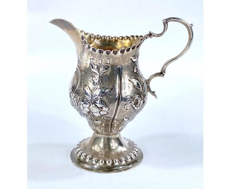 A Georgian hallmarked silver baluster cream jug with embossed decoration, on pedestal base, London 1774, 2.5 oz 