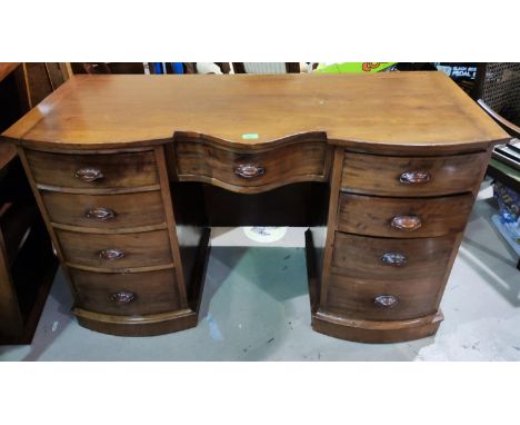 A 19th mahogany serpentine front writing desk with one frieze an 8 pedestal drawers with carved finger tip handles, width 127