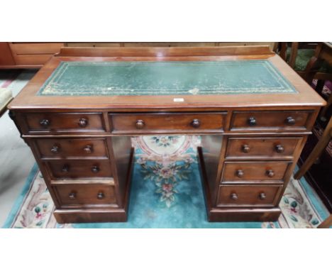 A 19th century mahogany kneehole desk with 3 frieze and 3 pedestal drawers and 3 false fascias with inset green leather writi