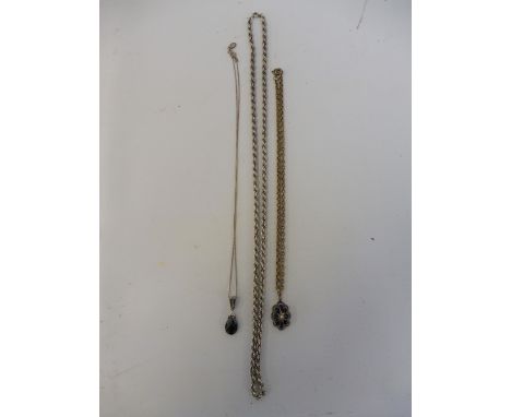 A heavy silver rope twist necklace, an unusual pendant possibly glass, set in yellow metal (probably gold), inset with a seed