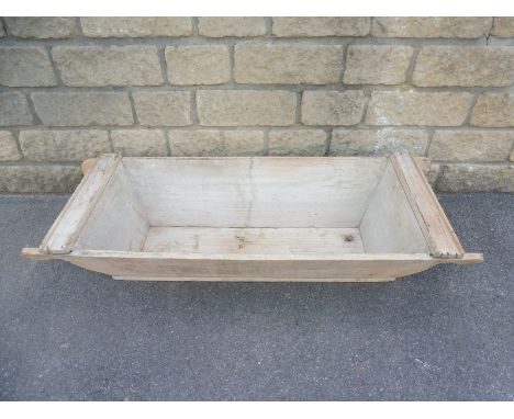 A 19th Century pine flour trough with shaped carrying handles, 51 1/2" w x 10" h x 19 3/4" d.