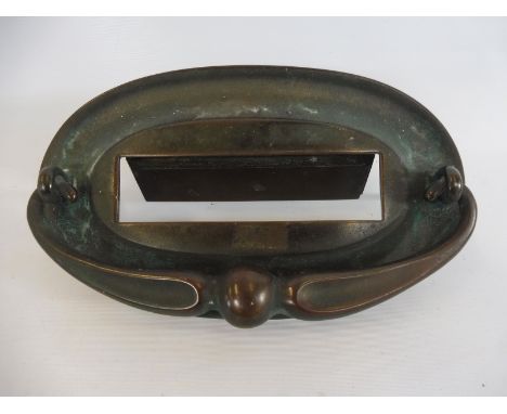 An Art Nouveau oval brass letter box plate, with integral door knocker, 8 1/2" x 5".