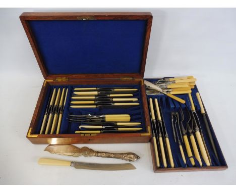 An oak cased part canteen of cutlery including carving tools, fish serving knife etc.