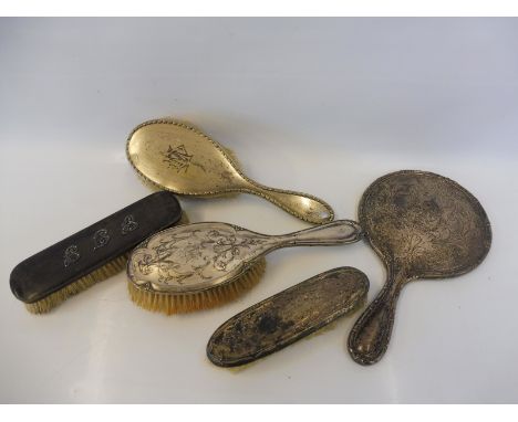 A set of three silver backed dressing table brushes and mirror plus two further brushes. 