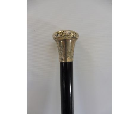 A silver topped ebonised walking cane, the knop with stylised decoration, London hallmark, date mark indistinct, maker BM &am