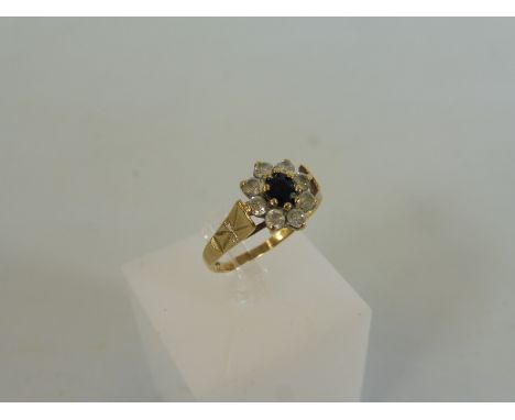 A 9ct gold ring set with a cental dark coloured stone surrounded by cz, weight approx. 2g.