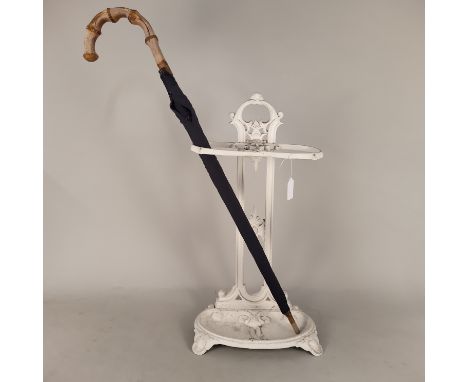 A cast iron white painted stick stand with umbrella