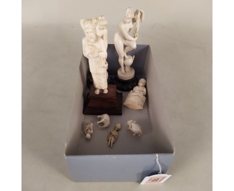 A pair of carved ivory figurines in female form, one of a ballerina, the other of a bather, mounted on stone bases, 6" high p