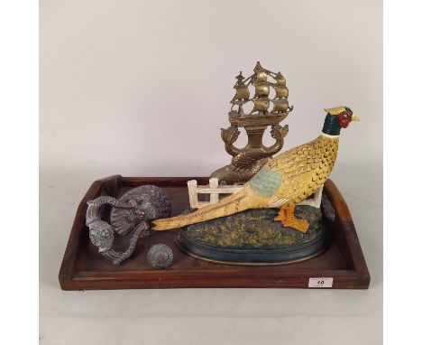 A brass dolphin doorstop, a painted cast iron pheasant doorstop, a brass lions head door knocker plus a wooden tray