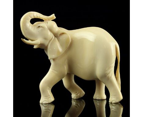 African Ivory Carved Figure of an Elephant. Carved in a walking position with his trunk raised above his head. Height: 11cm /