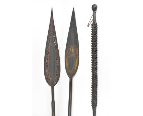 Two tribal carved ceremonial paddles, each with an elongated leaf shape paddle, 161cm high and 158cm high, together with  a t
