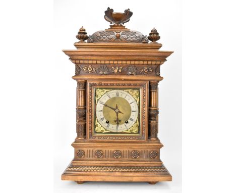 A late 19th century German walnut cased 8 day mantle clock, the case of architectural form having a platform finial above a s