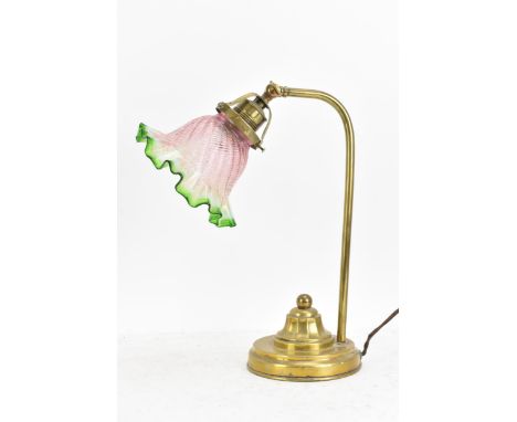 An early 20th century brass table lamp, having a single arm, an adjustable head and an Art Deco green and pink glass moulded 