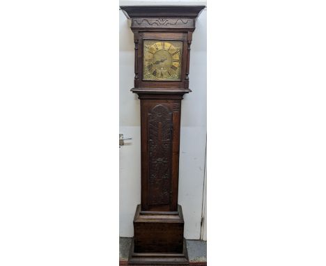 An early 18th century oak cased 30 hour longcase clock, the case having a moulded cornice with a later carved door, the squar