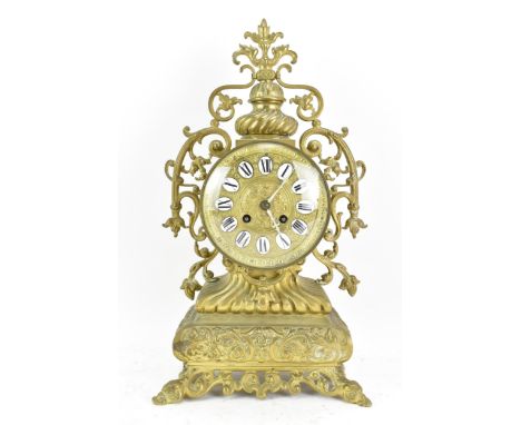 A 19th century French brass mantle clock, the ornate case having pierced floral scroll work frame, the gilt dial having ename