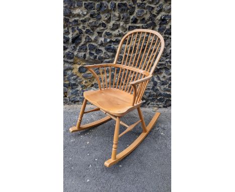 A Stewart Linford Windsor ash, elm and beech stick back rocking chair, in the Ercol style, having a hoop back with spindle su