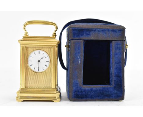 A late 19th century French gilt metal miniature carriage clock, having machine turned decoration and a white enamel dial with
