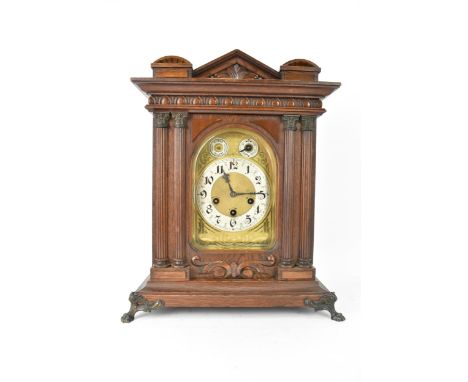 A circa 1900 Junghans oak cased mantle clock, the case of architectural form with egg and dart moulding above four Corinthian