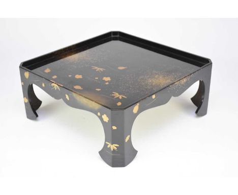 A Japanese lacquer small table, Meiji/Taisho era, of canted square form raised on axe-head feet and decorated with scattered 