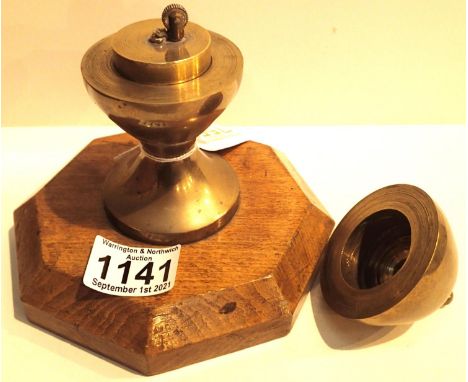 Antique trench art brass table gear lighter on octagonal mahogany base. P&amp;P Group 2 (£18+VAT for the first lot and £3+VAT