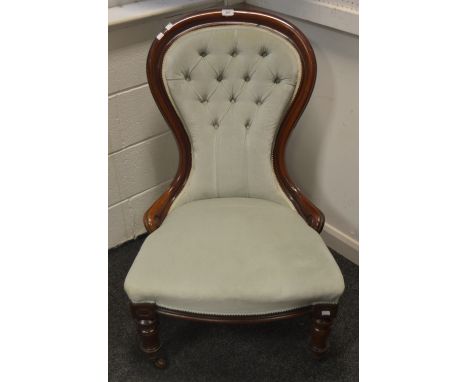 A Victorian mahogany spoon back nursing chair, deep button back, stuffed over seat, turned forelegs, ceramic casters, c.1880.