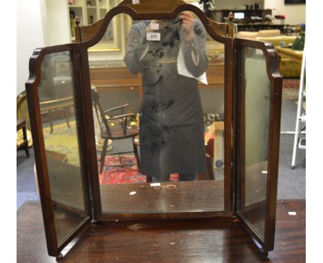 A triptych dressing mirror, cupid's bow shaped tilting mirror flanked by shaped mirrors, bun feet.