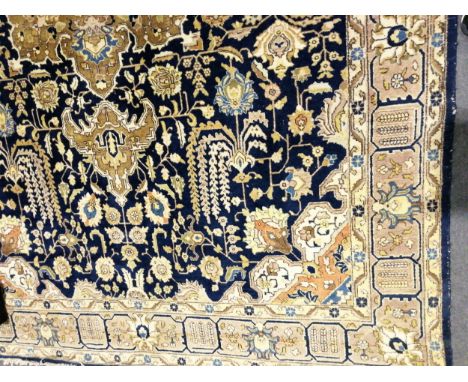 Kashan style carpet, central medallion on a flower field blue ground, border within guards, 400cm x 280cm.