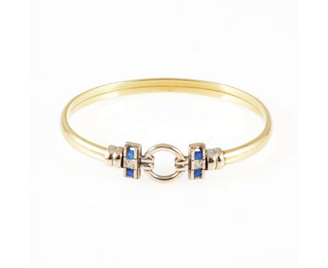 A modern yellow and white 5mm wide metal bangle with circular motif to front and set with one white and two blue synthetic wh