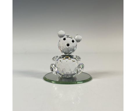 A clear faceted round sitting bear with black eyes and nose. Part of the Woodland Friends collection. Swarovski marking. Incl