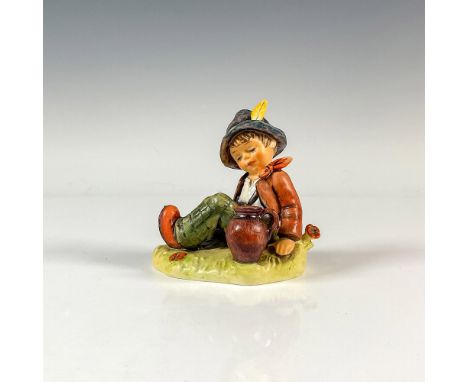 A matte hand painted figure of a boy wearing green plaid pants and an orange coat sitting on the grass with a pot. No. 8 Spec