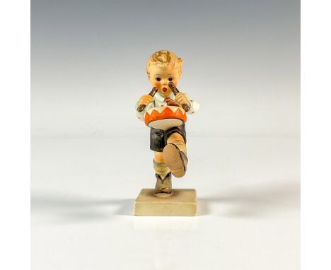 A figure of a young boy marching as he is playing a drum. M.I. Hummel impressed. Goebel backstamp. Issued: 1955-2009Dimension
