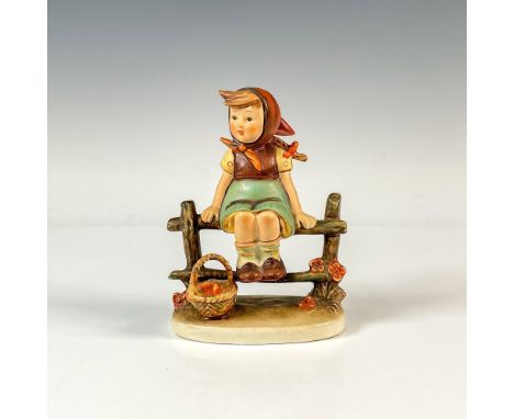 Matte hand painted figure of a young girl sitting on a fence with her fruit basket. M.I. Hummel impressed. Goebel backstamp. 