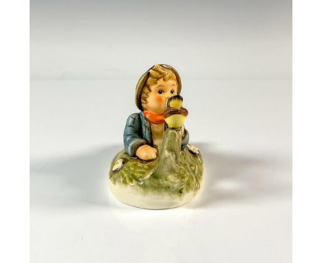 Figure of a boy lying on the ground as he is talking to his bird friend. M.I. Hummel impressed. Hummel backstamp. Issued: 200