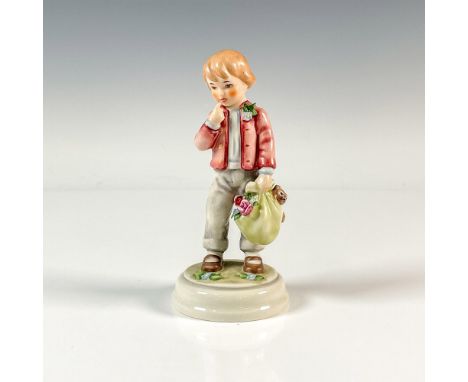 A figure of a child wearing a red coat and gray pants, holding a bag of toys and flowers as he embarks on a day trip. Part of