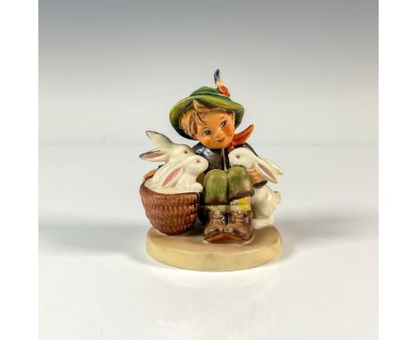 A hand painted matte and glossy figure of a boy sitting with his rabbit friends. M.I. Hummel impressed. Goebel backstamp. Dim