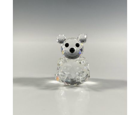 A clear faceted figure of a sitting bear with pointed paws and black eyes. Swarovski marking. This item has its original box: