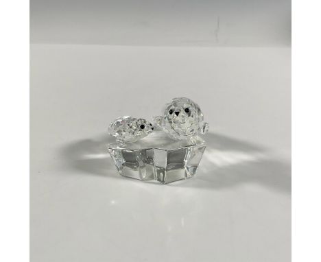 A clear faceted figure of a mother seal and her pup, both with black eyes and nose, resting atop a clear smooth ice floe. 199