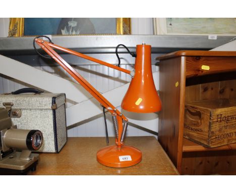 An orange Angle Poise type lamp 