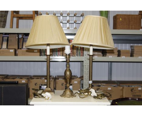 A pair of brass table lamps and shades together with a single brass table lamp