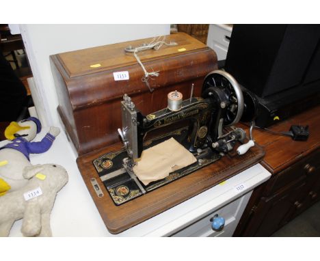 A Frister &amp; Rossman hand cranked sewing machine circa 1920 with case, key and manual