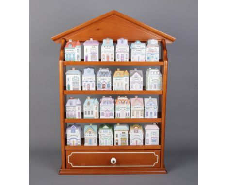 A complete set of 1991 "Brooks &amp; Bentley" twenty-four house-shaped herb and spice jars with spice rack. Rack size W29 x D