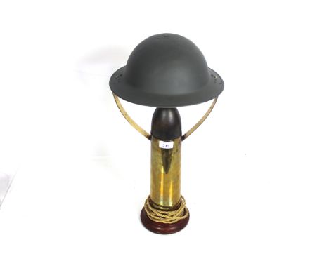 A lamp crafted from brass shell case with dummy head and period helmet as  a shade 