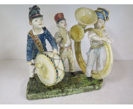 An Italian Majolica group of three young boys playing a horn and percussion - Height 28cm x 27cm x 18cmCondition report: Some