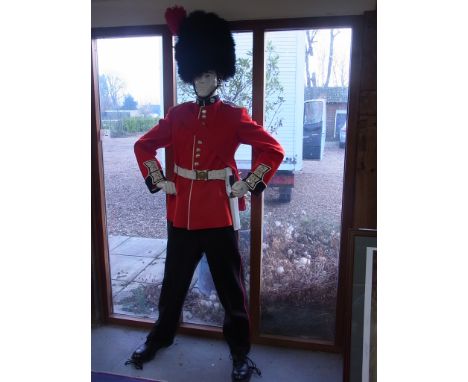 A Coldstream Guard uniform on a mannequin with busby, tunic, sash, bayonet and belt, trouser boots and socks - in good condit