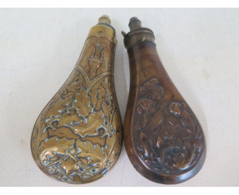Two copper powder flasks with embossed design one with birds amongst foliage one with Stags head over oak leaves to bodies Sp