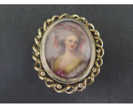 A 19th century pinchbeck swivel brooch in gilt metal with miniature portrait of a lady to centre