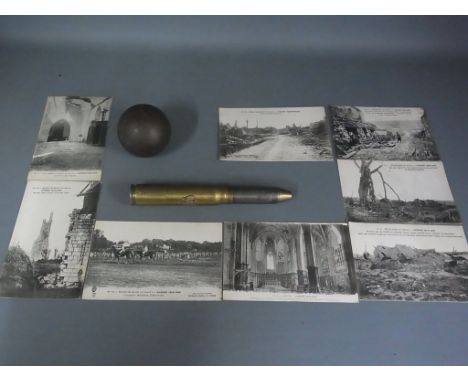 A 1942  20mm shell converted to a lighter with polish emblem, a Cannon ball and eight postcards, monochrome showing scenes of