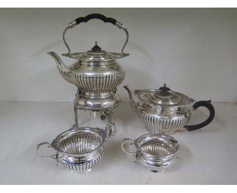 A silver hallmarked tea service consisting of teapot on stand with spirit burner below, teapot milk and sugar hallmarked for 