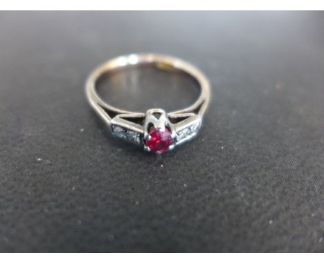 A 9ct yellow gold ring with four small diamonds and a ruby set to shoulder - ring size Q - approx weight 2.2 grams - surface 